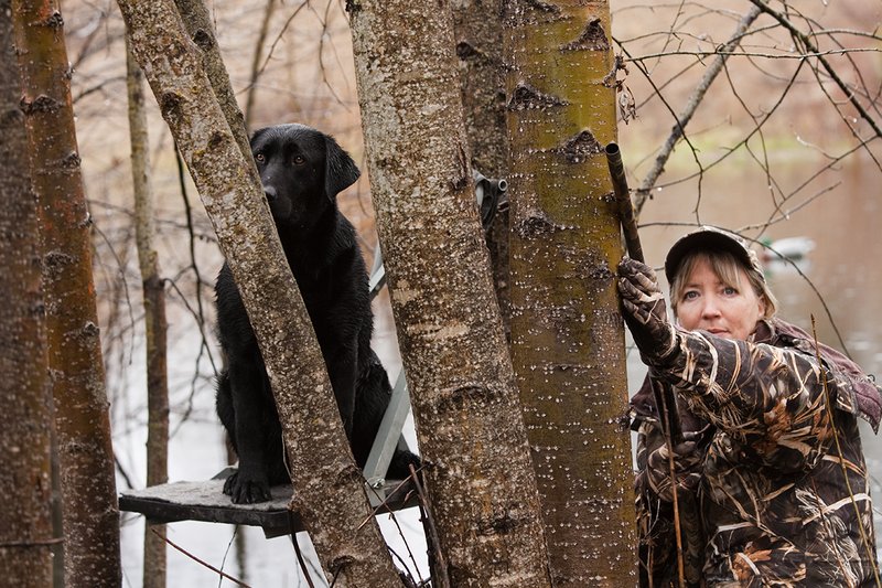 TC-Hunt-Women Waterfowl-D90081-00083.jpg :: Women Hunting Waterfowl in Flooded Timber, Advantage MaX-4HD Camo, Black Lab dog on platform