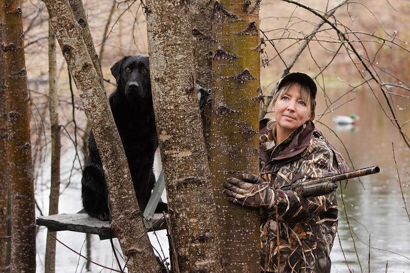 TC-Hunt-Women Waterfowl-D90081-00090.jpg :: Women Hunting Waterfowl in Flooded Timber, Advantage MaX-4HD Camo, Black Lab dog on platform