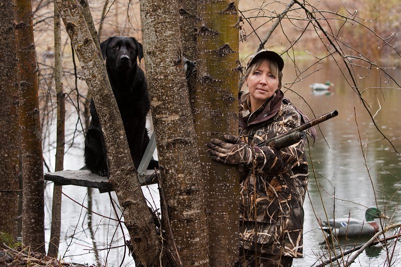 TC-Hunt-Women Waterfowl-D90081-00097.jpg :: Women Hunting Waterfowl in Flooded Timber, Advantage MaX-4HD Camo, Black Lab dog on platform