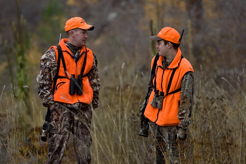 TC-Hunter Parent Child-D89995-00459.jpg :: Father (Jeff Christie) pauses to talk with his son Jon while standing in open timber while on Jon's first deer hunt.