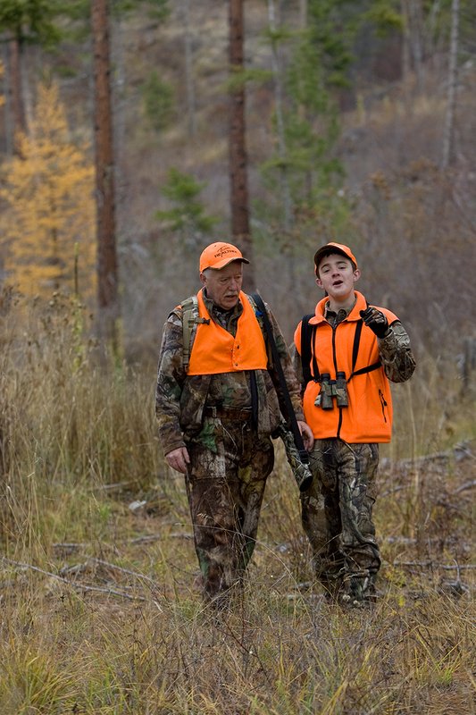 TC-Hunter Parent Child-D89995-00470.jpg :: Grandfather (Tim Christie) talks with his grandson Jon as they walk down a two track road while deer hunting on Jon's first deer hunt.