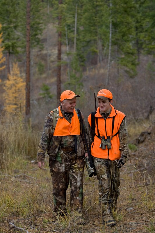 TC-Hunter Parent Child-D89995-00472.jpg :: Grandfather (Tim Christie) talks with his grandson Jon as they walk down a two track road while deer hunting on Jon's first deer hunt.