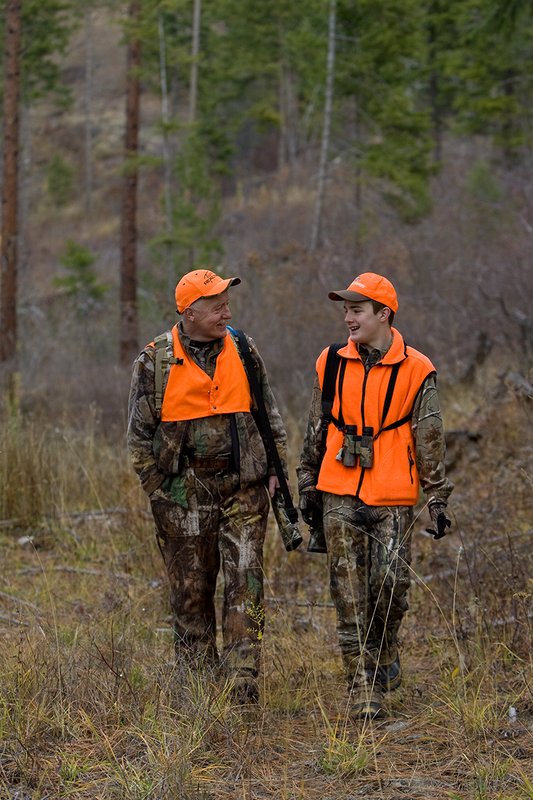 TC-Hunter Parent Child-D89995-00479.jpg :: Grandfather (Tim Christie) talks with his grandson Jon as they walk down a two track road while deer hunting on Jon's first deer hunt.