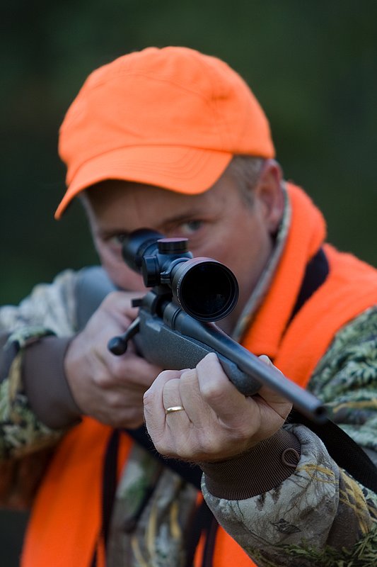 TC-Rifle Hunters-D90000-01271.jpg :: Rifle hunter wearing Realtree Max 1 camo and a florescent orange vest and hat aiming a custom Remington Model 700 topped with a Sightron 3x9 Big Sky Rifle scope