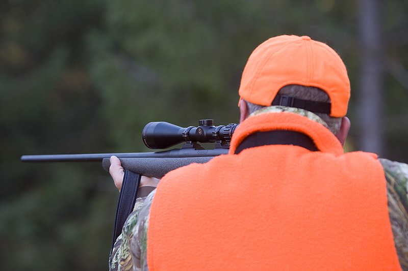 TC-Rifle Hunters-D90000-01272.jpg :: Rifle hunter wearing Realtree Max 1 camo and a florescent orange vest and hat aiming a custom Remington Model 700 topped with a Sightron 3x9 Big Sky Rifle scope