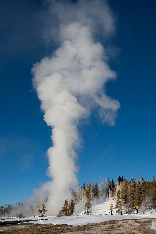 TC-Yellowstone winter-DYNP-W-00204.jpg :: Winter visitors to  Yellowstone National Park watch the Grand Geyser errupting in fridgid January air against a blue sky