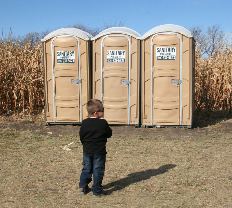 Hurry Up FINAL.jpg :: Small boy is anxiously waiting to use the Johnny after venturing through the corn maze in Pleasant Hill, Missouri