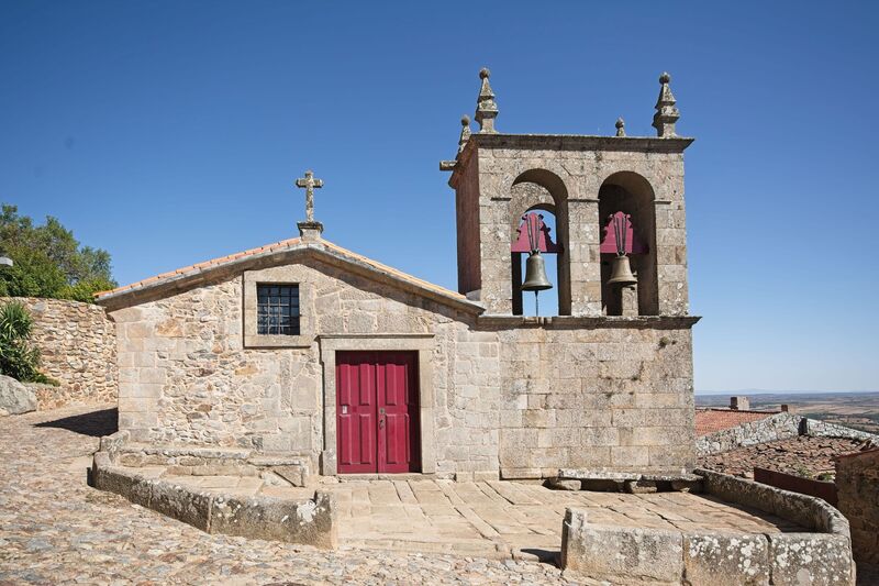 DC 22-0791-056.jpg :: Saga Douro River Cruise, Barca d'Alva, Castelo Rodrigo: The Mother Church is dedicated to Our Lady of Rocamador, and was founded in the thirteenth century by the Confraternity of the Friars of Our Lady of Rocamador, a congregation that was dedicated to assisting Compostela pilgrims. The Property maintains the primitive typology, it is an example of transition between Romanesque and Gothic, but it underwent later works, namely in the sixteenth and seventeenth centuries, which changed the structure of the temple. It has a composite plan, three naves, straight lintel porticoes and angular pediment. Inside we can admire a wooden coffered ceiling painted with hagiographic scenes, in the chancel eighteenth-century blue and white tiles and in the main altar Hispano-Arabic tiles. The Church was restored in the late 90s as part of the Historical Villages of Portugal Program. Photo taken 31/08/2022