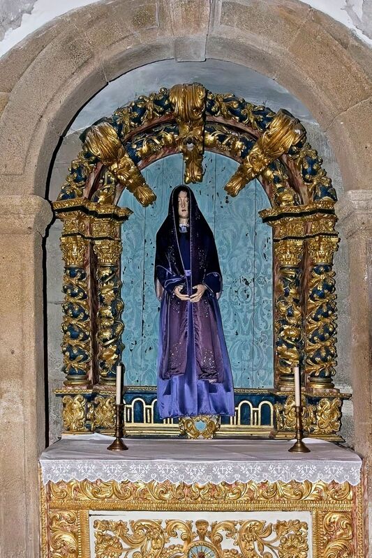 DC 22-0791-065.jpg :: Saga Douro River Cruise, Barca d'Alva, Castelo Rodrigo: The Mother Church is dedicated to Our Lady of Rocamador, and was founded in the thirteenth century by the Confraternity of the Friars of Our Lady of Rocamador, a congregation that was dedicated to assisting Compostela pilgrims. The Property maintains the primitive typology, it is an example of transition between Romanesque and Gothic, but it underwent later works, namely in the sixteenth and seventeenth centuries, which changed the structure of the temple. It has a composite plan, three naves, straight lintel porticoes and angular pediment. Inside we can admire a wooden coffered ceiling painted with hagiographic scenes, in the chancel eighteenth-century blue and white tiles and in the main altar Hispano-Arabic tiles. The Church was restored in the late 90s as part of the Historical Villages of Portugal Program. Photo taken 31/08/2022