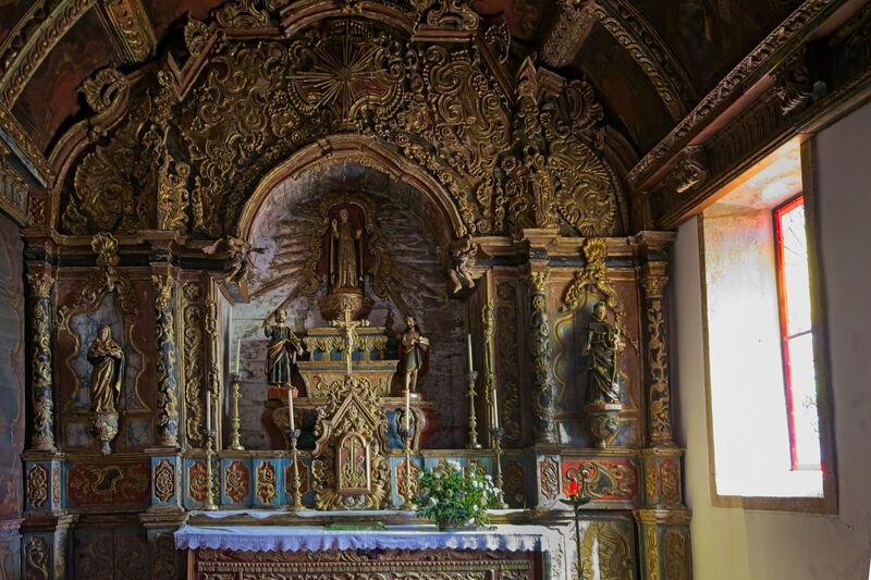 DC 22-0791-067.jpg :: Saga Douro River Cruise, Barca d'Alva, Castelo Rodrigo: The Mother Church is dedicated to Our Lady of Rocamador, and was founded in the thirteenth century by the Confraternity of the Friars of Our Lady of Rocamador, a congregation that was dedicated to assisting Compostela pilgrims. The Property maintains the primitive typology, it is an example of transition between Romanesque and Gothic, but it underwent later works, namely in the sixteenth and seventeenth centuries, which changed the structure of the temple. It has a composite plan, three naves, straight lintel porticoes and angular pediment. Inside we can admire a wooden coffered ceiling painted with hagiographic scenes, in the chancel eighteenth-century blue and white tiles and in the main altar Hispano-Arabic tiles. The Church was restored in the late 90s as part of the Historical Villages of Portugal Program. Photo taken 31/08/2022