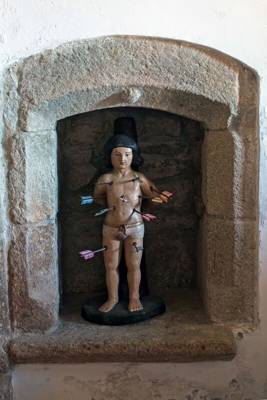 DC 22-0791-072.jpg :: Saga Douro River Cruise, Barca d'Alva, Castelo Rodrigo: The Mother Church is dedicated to Our Lady of Rocamador, and was founded in the thirteenth century by the Confraternity of the Friars of Our Lady of Rocamador, a congregation that was dedicated to assisting Compostela pilgrims. The Property maintains the primitive typology, it is an example of transition between Romanesque and Gothic, but it underwent later works, namely in the sixteenth and seventeenth centuries, which changed the structure of the temple. It has a composite plan, three naves, straight lintel porticoes and angular pediment. Inside we can admire a wooden coffered ceiling painted with hagiographic scenes, in the chancel eighteenth-century blue and white tiles and in the main altar Hispano-Arabic tiles. The Church was restored in the late 90s as part of the Historical Villages of Portugal Program. St. Sebastian is honoured in the Church. Photo taken 31/08/2022