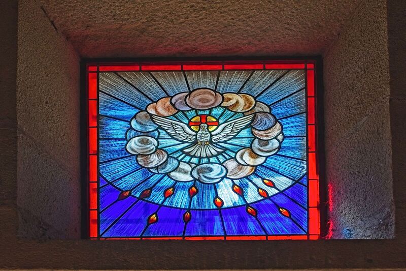 DC 22-0791-076.jpg :: Saga Douro River Cruise, Barca d'Alva, Castelo Rodrigo: The Mother Church is dedicated to Our Lady of Rocamador, and was founded in the thirteenth century by the Confraternity of the Friars of Our Lady of Rocamador, a congregation that was dedicated to assisting Compostela pilgrims. The Property maintains the primitive typology, it is an example of transition between Romanesque and Gothic, but it underwent later works, namely in the sixteenth and seventeenth centuries, which changed the structure of the temple. It has a composite plan, three naves, straight lintel porticoes and angular pediment. Inside we can admire a wooden coffered ceiling painted with hagiographic scenes, in the chancel eighteenth-century blue and white tiles and in the main altar Hispano-Arabic tiles. The Church was restored in the late 90s as part of the Historical Villages of Portugal Program. P.s This is a stained glass window depicting the Holy Spirit, often referred to as the \