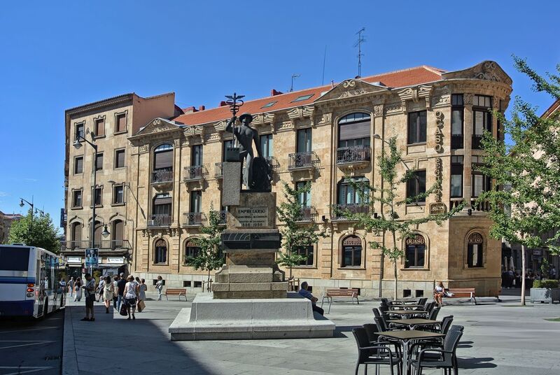 DC 22-0794-026a.jpg :: Saga Douro River Cruise, Salamanca. Spain: This is the Monumento al Empresario (Monument to the Businessman) in Salamanca. The monument is located on the Gran Vía in Salamanca. It was created by the sculptor Gabriel Sánchez Calzada. The text on the pedestal refers to the Salamanca Official Chamber of Commerce (Cámara Oficial de Comercio) and the years 1886-1986. The figure holds a caduceus, a symbol often associated with commerce and negotiation. The bronze sculpture depicts the Roman god Mercury (Hermes in Greek mythology), who is considered the god of commerce, among other things. He is shown holding a caduceus, his traditional symbol, and wearing a hat. Photo taken 01/09/2022