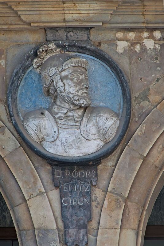 DC 22-0794-042.jpg :: Saga Douro River Cruise, Salamanca. Spain: The famous Plaza Mayor in Salamanca. Widely considered one of the most beautiful squares in the country, it is a significant example of Spanish Baroque architecture built in the 18th century. The Plaza Mayor is in the heart of Salamanca, a pedestrianized area that serves as the city's main social hub. It was primarily designed by architect Alberto Churriguera and completed in 1755. The buildings feature a uniform design of three stories, with arcades lining the perimeter and medallions depicting historic figures above the arches. Historically used for markets, bullfights, and public ceremonies, today the square is lined with numerous shops, restaurants, and cafes. It frequently hosts local events, concerts, and festivals, which explains the stage and seating setup. The image is a medallion featuring a bust of Rodrigo Téllez Girón, located on the Pabellón de San Martín in the Plaza Mayor of Salamanca. Rodrigo Téllez Girón was the Grand Master of the Order of Calatrava. He is a historical figure, known for his role during the reign of Queen Isabella I of Castile and King Ferdinand II of Aragon. The medallion is part of a series of busts of notable figures that decorate the plaza. Photo taken 01/09/2022