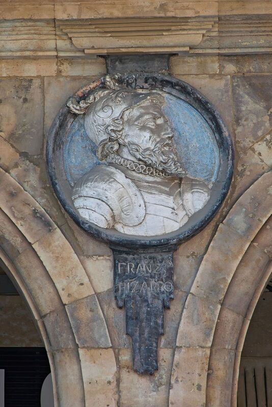 DC 22-0794-044.jpg :: Saga Douro River Cruise, Salamanca. Spain: he famous Plaza Mayor in Salamanca. Widely considered one of the most beautiful squares in the country, it is a significant example of Spanish Baroque architecture built in the 18th century. The Plaza Mayor is in the heart of Salamanca, a pedestrianized area that serves as the city's main social hub. It was primarily designed by architect Alberto Churriguera and completed in 1755. The buildings feature a uniform design of three stories, with arcades lining the perimeter and medallions depicting historic figures above the arches. Historically used for markets, bullfights, and public ceremonies, today the square is lined with numerous shops, restaurants, and cafes. It frequently hosts local events, concerts, and festivals, which explains the stage and seating setup. This medallion depicts Francisco Pizarro, the Spanish conquistador known for conquering the Inca Empire. The sculpture is an outdoor relief located in the Plaza Mayor of Salamanca. The medallion is part of a series of busts of notable figures that decorate the plaza. Photo taken 01/09/2022