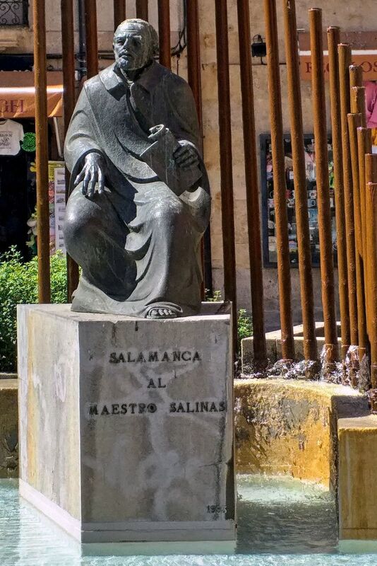 DC 22-0794-169.jpg :: Saga Douro River Cruise, Salamanca. Spain: The Monumento al Maestro Salinas (Monument to Maestro Salinas). The bronze sculpture, created by Hipólito Pérez Calvo and inaugurated in 1993, honours the life and work of Francisco de Salinas, a renowned 16th-century Spanish music theorist and organist. The statue depicts Francisco de Salinas, who became blind at age eleven but went on to become a famous musician and a professor of music at the University of Salamanca for over 20 years. The monument is situated in a triangular square at the intersection of Rúa Antigua, Rúa Mayor, and Calle Compañía. It is next to other significant landmarks, including the historic Casa de las Conchas and the Clerecía church (Pontifical University building). Photo taken 01/09/2022