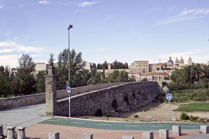 DC 22-0794-228.jpg :: Saga Douro River Cruise, Salamanca. Portugal: On route back to the cruise ship port at Barca d'Alva in Portugal. The Roman bridge of Salamanca (Puente Romano), an ancient bridge crossing the Tormes River in Salamanca. The original Roman section dates back to the 1st century AD, possibly built under the emperors Augustus or Vespasian. The bridge measures about 176 meters long and consists of 26 arches, but only the 15 arches closest to the city are of Roman origin; the rest are medieval reconstructions following various floods. It was the main point of access to Salamanca for centuries until a third, modern bridge was built. Since 1973, the Roman bridge has been exclusively a pedestrian walkway. It was a crucial part of the ancient Roman road known as the Vía de la Plata, which linked Mérida and Astorga. Photo taken 01/09/2022