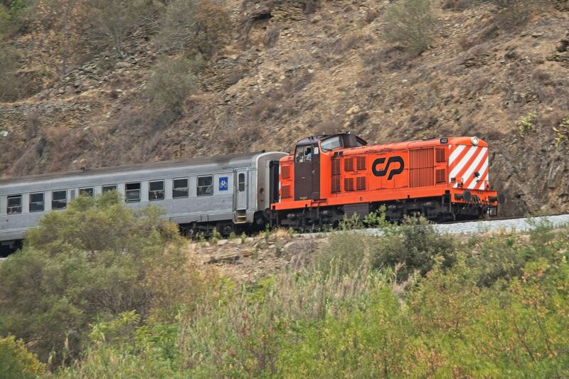 DC 22-0797-030.jpg :: Saga Douro River Cruise, Pocinho to Pinhao, River Douro: MS Douro Spirit passing the area of Castedo e Cotas on the River Douro. The locomotive in the image is a CP Class 1400, a series of diesel-electric locomotives built for the Portuguese Railways (CP). The train is operated by CP (Comboios de Portugal), the state-owned Portuguese railway company, as indicated by the logo on its side. The locomotives were designed by English Electric and built between 1967 and 1969. The first ten were built in England, while the rest were assembled in Portugal by Sorefame. The Class 1400 is mechanically based on the British Rail Class 20 locomotive but uses a more powerful engine and has its cab positioned away from the extreme end. These locomotives were originally ordered to replace the remaining steam locomotives in service. Many remain in service today, some with private operators. They are often seen on lines like the Douro Valley line. Photo taken 02/09/2022