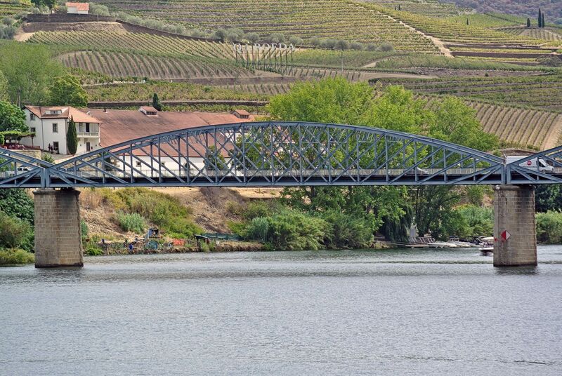 DC 22-0797-065.jpg :: Saga Douro River Cruise, Pocinho to Pinhao, River Douro: The Ponte do Pinhão, a steel road bridge crossing the Douro River in the village of Pinhão, Portugal. This bridge is often referred to as the Gustave Eiffel bridge as it was designed by the famous French engineer Gustave Eiffel and his firm. Spans the Douro River in Pinhão, Portugal, connecting both banks of the river in the heart of the Alto Douro Wine Region. Opened in 1903. It was designed in the late 19th century. It is a road bridge that carries traffic and has pedestrian walkways, serving as an essential link for local residents and a scenic spot for tourists. Photo taken 02/09/2022