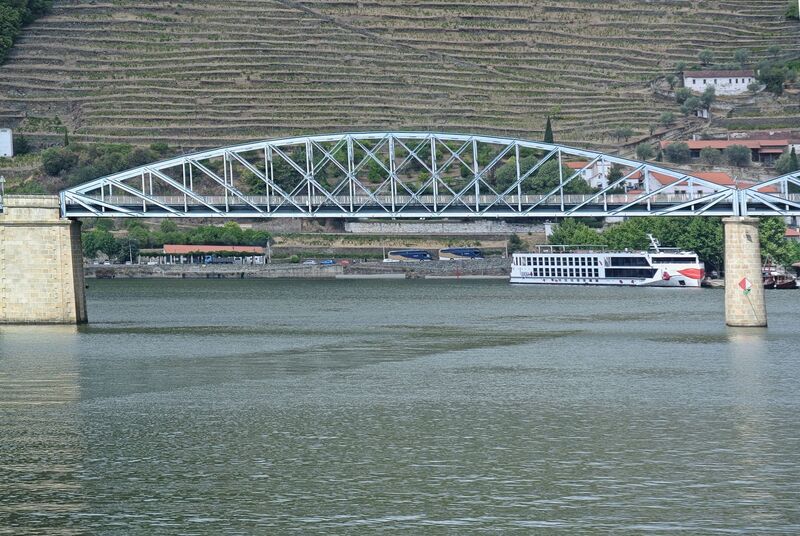 DC 22-0797-066.jpg :: Saga Douro River Cruise, Pocinho to Pinhao, River Douro: The Ponte do Pinhão, a steel road bridge crossing the Douro River in the village of Pinhão, Portugal. This bridge is often referred to as the Gustave Eiffel bridge as it was designed by the famous French engineer Gustave Eiffel and his firm. Spans the Douro River in Pinhão, Portugal, connecting both banks of the river in the heart of the Alto Douro Wine Region. Opened in 1903. It was designed in the late 19th century. It is a road bridge that carries traffic and has pedestrian walkways, serving as an essential link for local residents and a scenic spot for tourists. Photo taken 02/09/2022