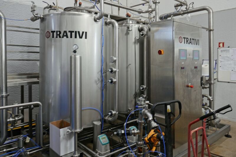 DC 22-0808-047.jpg :: Saga Douro River Cruise, Favaios:  The building in the image is the Adega Cooperativa de Favaios, a renowned winery located in the village of Favaios within the Douro wine region of Portugal. The winery is famous for producing one of Portugal's most iconic fortified wines, Moscatel de Favaios. The winery is nestled in the picturesque Alto Douro wine region of Portugal, a UNESCO World Heritage site. Founded in 1952, the cooperative was established by local producers to create their famous Moscatel wine. While most famous for its Moscatel, the winery also produces DOC Douro wines (white, red, and rosé), sparkling wines, and Port wine. Fermentation tanks. Photo taken 02/09/2022