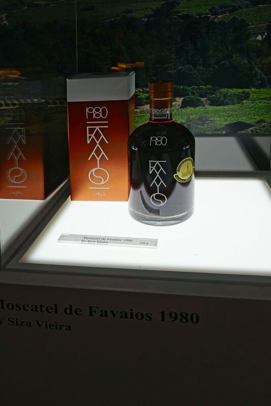 DC 22-0808-059.jpg :: Saga Douro River Cruise, Favaios:  The building in the image is the Adega Cooperativa de Favaios, a renowned winery located in the village of Favaios within the Douro wine region of Portugal. The winery is famous for producing one of Portugal's most iconic fortified wines, Moscatel de Favaios. The winery is nestled in the picturesque Alto Douro wine region of Portugal, a UNESCO World Heritage site. Founded in 1952, the cooperative was established by local producers to create their famous Moscatel wine. While most famous for its Moscatel, the winery also produces DOC Douro wines (white, red, and rosé), sparkling wines, and Port wine. Moscatel de Favaios 1980 by Siza Vieira Wines available for purchase. Photo taken 02/09/2022