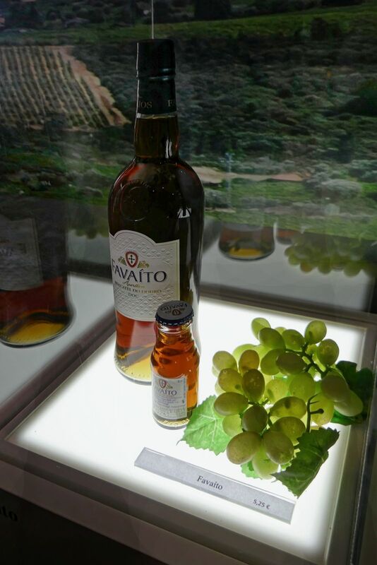 DC 22-0808-062.jpg :: Saga Douro River Cruise, Favaios:  The building in the image is the Adega Cooperativa de Favaios, a renowned winery located in the village of Favaios within the Douro wine region of Portugal. The winery is famous for producing one of Portugal's most iconic fortified wines, Moscatel de Favaios. The winery is nestled in the picturesque Alto Douro wine region of Portugal, a UNESCO World Heritage site. Founded in 1952, the cooperative was established by local producers to create their famous Moscatel wine. While most famous for its Moscatel, the winery also produces DOC Douro wines (white, red, and rosé), sparkling wines, and Port wine. Favaito Wines available for purchase. Photo taken 02/09/2022