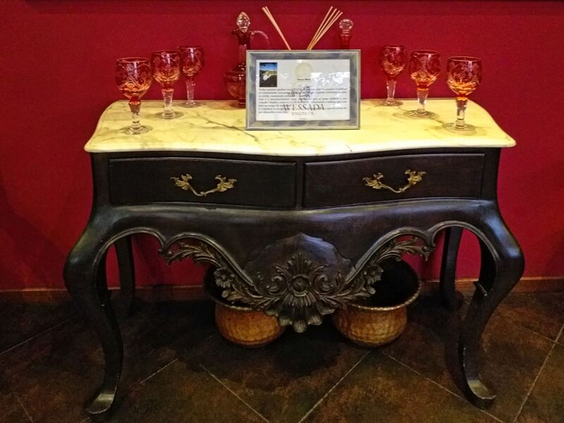 DC 22-0808-080.jpg :: Saga Douro River Cruise, Favaios, Avessada Wine Estate: Quinta da Avessada is located in the centre of the Douro demarcated region at its highest point (at an altitude of 600 meters) and the flattest point in the whole region (about 1,000ha of plateau), consisting of four buildings (one of them is one hundred years old) and 25ha of planting. Due to this, 90% of its plantation is destined to the production of Muscat grapes, with which Moscatel de Favaios is produced, and is designated a national apéritif. It is the Wine-Growing Village of Favaios. Antique table. Photo taken 02/09/2022