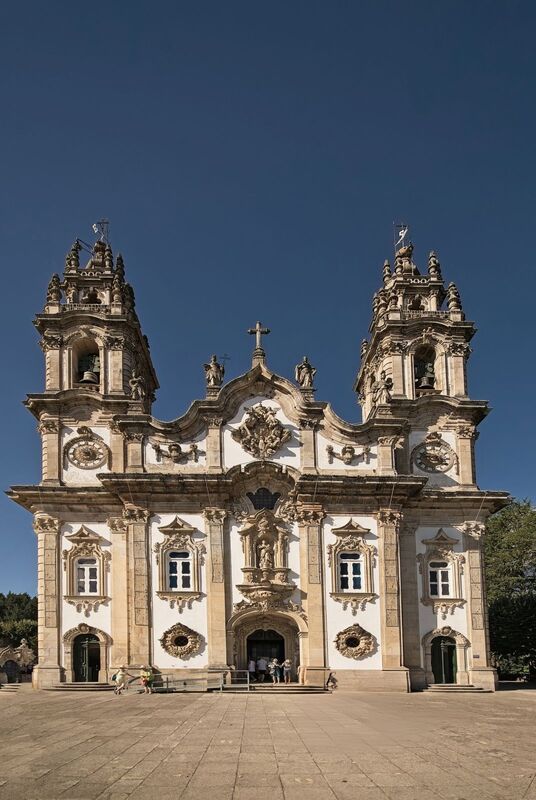 DC 22-0810-003.jpg :: Saga Douro River Cruise, Santuario de Nossa Senhora dos Remedios and Regua: The Santuário de Nossa Senhora dos Remédios (Sanctuary of Our Lady of Remedies), a famous pilgrimage site and 18th-century Baroque sanctuary in Lamego, Portugal. The sanctuary is a prominent example of Baroque-style architecture, known for its highly ornate and detailed façade. The site's most iconic feature is a magnificent zigzagging staircase leading up to the church. It consists of 686 steps across nine terraces. The complex is embellished with decorative fountains, statues, and terraced gardens at each level of the staircase. One notable fountain outside is said by some to have healing waters. It is situated atop the Hill of St. Stephen (Monte de Santo Estêvão), offering panoramic views of the town of Lamego and the surrounding Douro Valley. Construction of the present Baroque shrine began in the mid-18th century, though the site has earlier religious roots as a hermitage. Today, it remains one of the major pilgrimage centres in Portugal, where pilgrims traditionally climb the hundreds of steps as an act of reflection and meditation. Photo taken 03/09/2022