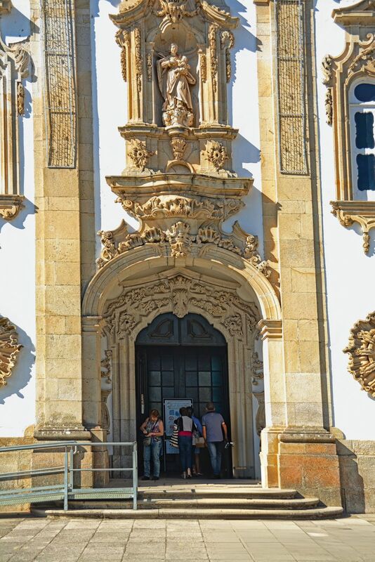 DC 22-0810-007.jpg :: Saga Douro River Cruise, Santuario de Nossa Senhora dos Remedios and Regua: The ornate baroque entrance to the Santuário de Nossa Senhora dos Remédios (Sanctuary of Our Lady of Remedies) in Lamego, Portugal. The architectural style is a notable example of Portuguese Baroque, featuring intricate stone carvings and a statue niche above the doorway. It is a major landmark in the Douro region of northern Portugal. Photo taken 03/09/2022