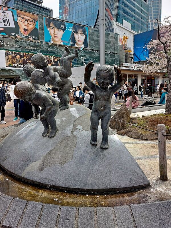 DC 23-0677-030.jpg :: Iglu Tour, Ultimate Japan & Cherry Blossom: Tokyo, Japan, A sculpture of young boys playing on the globe. Located outside Tokyo's Shibuya Station. Photo taken 31/03/2023