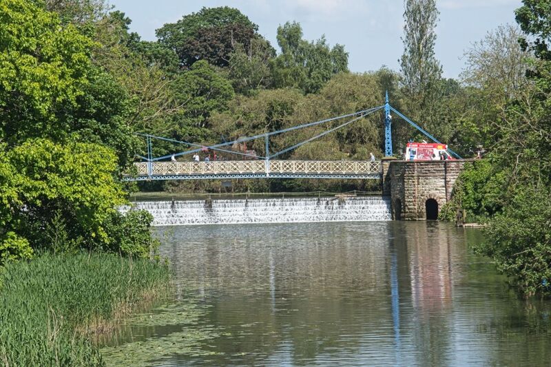 DC 24-0720-074.jpg :: Royal Leamington Spa: Mill Bridge and Weir with Walls and Railings Adjoining. A Grade II Listed Building in Royal Leamington Spa. Suspension bridge, weir, retaining walls, walls and piers, surmounting lamps and railings. Dated 1903. By William de Normanville, Borough Engineer. Bridge approximately 26 metres in 3 bays and with end towers. Photo taken 18/05/2024