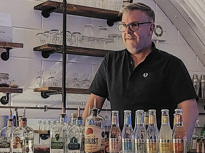 DC 24-0721-003.jpg :: Warwickshire Gin Company, Leamington Spa: Dave Blick, host for the gin tasting experience. This is a liquor store with a range of gins, rums. The range of gins here is inspired by local historical events, developing flavours that represent the unique story of the place, and making it happen by hand. Warwickshire Gin Company dabbles in craft gin distilling all things new and undiscovered. Photo taken 19/05/2024