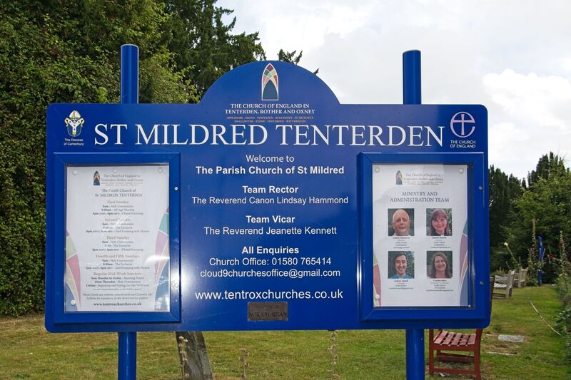 DC 24-0736-001.jpg :: Tenterden, Kent: St. Mildred's Church is an Anglican church located in Tenterden in the borough of Ashford in Kent. The church dates from about the 12th century and is Grade I heritage listed. The main tower of the church is 39.6 metres (130 feet) high and was constructed in 1461. It is dedicated to a prominent Anglo-Saxon saint, Saint Mildred, a 7th-century princess who served as the abbess of the nunnery at Minister-in-Thanet. The main tower of the church is built from Bethersden Marble, a limestone that contains thousands of brightly coloured shells. A graveyard is also present on the left-hand side of the church. Photo taken 04/09/2024