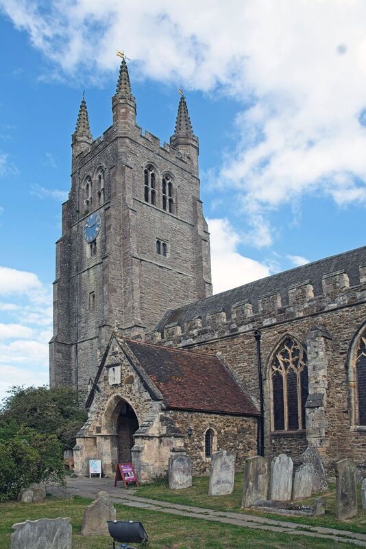 DC 24-0736-004.jpg :: Tenterden, Kent: St. Mildred's Church is an Anglican church located in Tenterden in the borough of Ashford in Kent. The church dates from about the 12th century and is Grade I heritage listed. The main tower of the church is 39.6 metres (130 feet) high and was constructed in 1461. It is dedicated to a prominent Anglo-Saxon saint, Saint Mildred, a 7th-century princess who served as the abbess of the nunnery at Minister-in-Thanet. The main tower of the church is built from Bethersden Marble, a limestone that contains thousands of brightly coloured shells. A graveyard is also present on the left-hand side of the church. Photo taken 04/09/2024