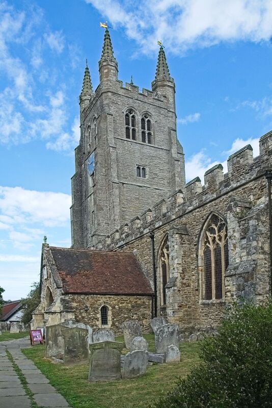 DC 24-0736-005.jpg :: Tenterden, Kent: St. Mildred's Church is an Anglican church located in Tenterden in the borough of Ashford in Kent. The church dates from about the 12th century and is Grade I heritage listed. The main tower of the church is 39.6 metres (130 feet) high and was constructed in 1461. It is dedicated to a prominent Anglo-Saxon saint, Saint Mildred, a 7th-century princess who served as the abbess of the nunnery at Minister-in-Thanet. The main tower of the church is built from Bethersden Marble, a limestone that contains thousands of brightly coloured shells. A graveyard is also present on the left-hand side of the church. Photo taken 04/09/2024