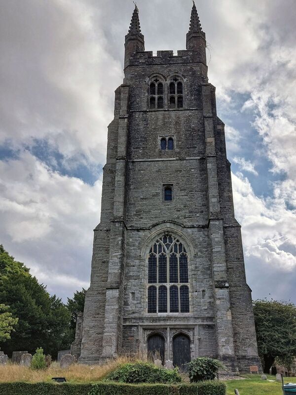 DC 24-0736-014.jpg :: Tenterden, Kent: St. Mildred's Church is an Anglican church located in Tenterden in the borough of Ashford in Kent. The church dates from about the 12th century and is Grade I heritage listed. The main tower of the church is 39.6 metres (130 feet) high and was constructed in 1461. It is dedicated to a prominent Anglo-Saxon saint, Saint Mildred, a 7th-century princess who served as the abbess of the nunnery at Minister-in-Thanet. The main tower of the church is built from Bethersden Marble, a limestone that contains thousands of brightly coloured shells. A graveyard is also present on the left-hand side of the church. Photo taken 04/09/2024