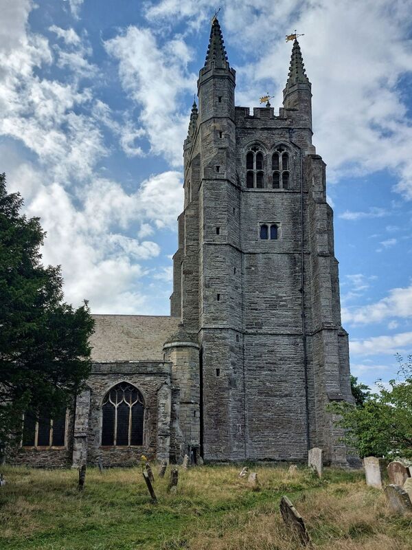 DC 24-0736-015.jpg :: Tenterden, Kent: St. Mildred's Church is an Anglican church located in Tenterden in the borough of Ashford in Kent. The church dates from about the 12th century and is Grade I heritage listed. The main tower of the church is 39.6 metres (130 feet) high and was constructed in 1461. It is dedicated to a prominent Anglo-Saxon saint, Saint Mildred, a 7th-century princess who served as the abbess of the nunnery at Minister-in-Thanet. The main tower of the church is built from Bethersden Marble, a limestone that contains thousands of brightly coloured shells. A graveyard is also present on the left-hand side of the church. Photo taken 04/09/2024