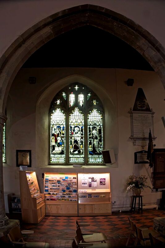 DC 24-0736-024.jpg :: Tenterden, Kent: St. Mildred's Church is an Anglican church located in Tenterden in the borough of Ashford in Kent. The church dates from about the 12th century and is Grade I heritage listed. The main tower of the church is 39.6 metres (130 feet) high and was constructed in 1461. It is dedicated to a prominent Anglo-Saxon saint, Saint Mildred, a 7th-century princess who served as the abbess of the nunnery at Minister-in-Thanet. The main tower of the church is built from Bethersden Marble, a limestone that contains thousands of brightly coloured shells. A graveyard is also present on the left-hand side of the church. Stained glass windows. Centre Light - King Edward VII and Queen Alexandra crowned 9th day of August 1902. Outer Lights - Remember Albert Edward Bright and William Bright. Window by TF Curtis, Ward & Hughes 1902. Photo taken 04/09/2024