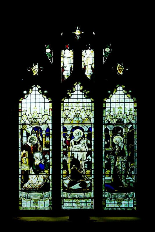 DC 24-0736-025.jpg :: Tenterden, Kent: St. Mildred's Church is an Anglican church located in Tenterden in the borough of Ashford in Kent. The church dates from about the 12th century and is Grade I heritage listed. The main tower of the church is 39.6 metres (130 feet) high and was constructed in 1461. It is dedicated to a prominent Anglo-Saxon saint, Saint Mildred, a 7th-century princess who served as the abbess of the nunnery at Minister-in-Thanet. The main tower of the church is built from Bethersden Marble, a limestone that contains thousands of brightly coloured shells. A graveyard is also present on the left-hand side of the church. Stained glass windows. Centre Light - King Edward VII and Queen Alexandra crowned 9th day of August 1902. Outer Lights - Remember Albert Edward Bright and William Bright. Window by TF Curtis, Ward & Hughes 1902. Photo taken 04/09/2024