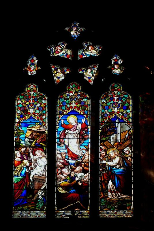 DC 24-0736-029.jpg :: Tenterden, Kent: St. Mildred's Church is an Anglican church located in Tenterden in the borough of Ashford in Kent. The church dates from about the 12th century and is Grade I heritage listed. The main tower of the church is 39.6 metres (130 feet) high and was constructed in 1461. It is dedicated to a prominent Anglo-Saxon saint, Saint Mildred, a 7th-century princess who served as the abbess of the nunnery at Minister-in-Thanet. The main tower of the church is built from Bethersden Marble, a limestone that contains thousands of brightly coloured shells. A graveyard is also present on the left-hand side of the church. Stained glass window. Steadfast in Faith, Joyful through Hope. Rooted in Chatrity - Ward & Hughes 1866. Photo taken 04/09/2024