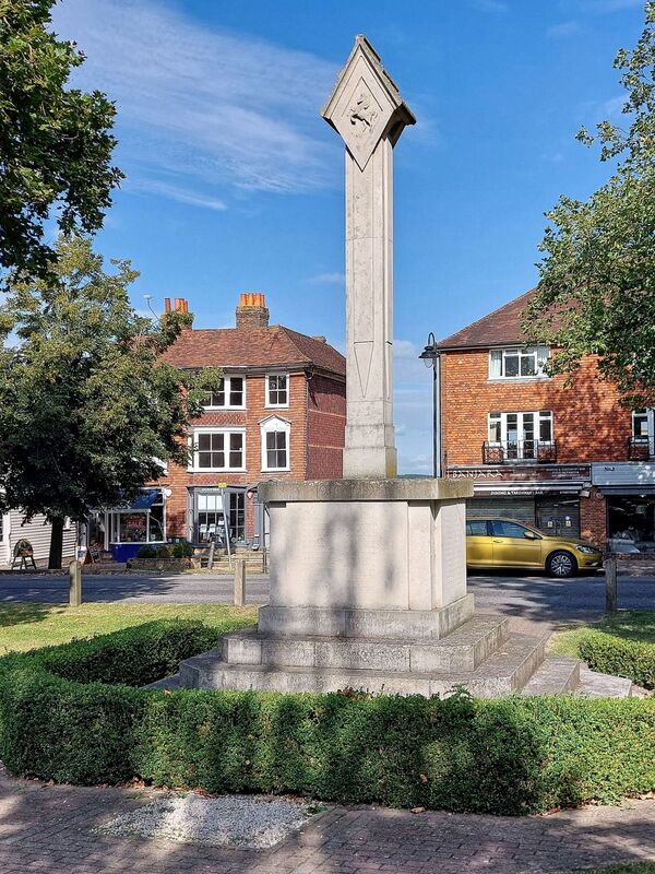 DC 24-0736-046.jpg :: Tenterden, Kent: Tenterden War Memorial, located in High Street Tenterden. Designed by W. Wirigley Diggle and sculptured by N. Hitch. It features a square-section shaft on a plinth with four octagonal steps, topped by a stylised lantern with the Arms of Tenterden and Crest of the County of Kent. The four steps are said to represent the four years of World war 1, within the base representing the fifth year. Dedicated in 1920, the memorial commemorates the lives of local men lost in both wars, with, names added for Worls War 2 fatalities. The memorial is listed at grade II for its historical and architectural interest. Photo taken 04/09/2024