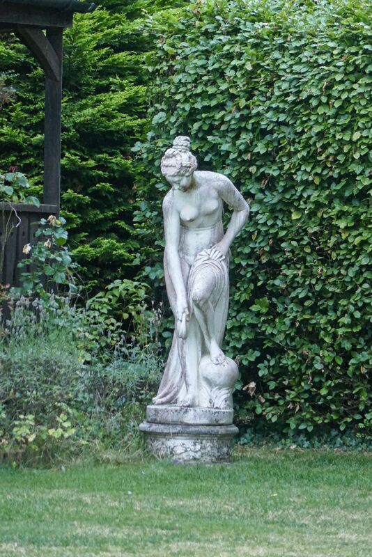 DC 24-0736-079.jpg :: Tenterden, Kent: Little Silver Country Hotel, a former 16-bedroom hotel and wedding venue on Ashford Road in Tenterden. The main part of the property features a mock-Tudor façade and dates back to the mid-20th century. Garden statue of the Bathing Venus. This 20th century cast stone statue is a reproduction of the original Bathing Venus by Christophe-Gabriel Allegrain (17110-1795). The statue depicts Venus, the Roman goddess of love, beauty, pleasure and fertility, in a bathing pose. Photo taken 04/09/2024