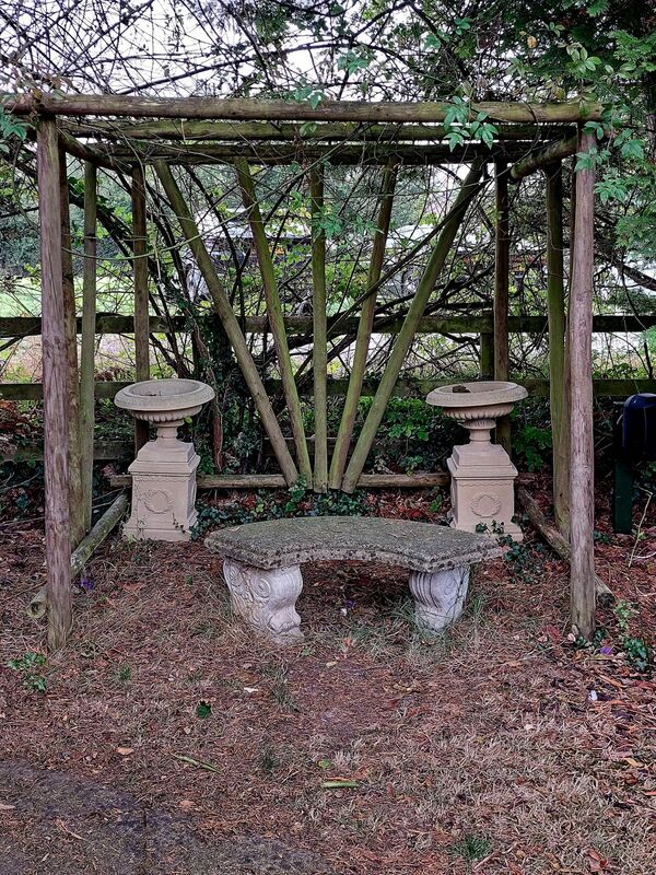 DC 24-0736-082.jpg :: Tenterden, Kent: Little Silver Country Hotel, a former 16-bedroom hotel and wedding venue on Ashford Road in Tenterden. The main part of the property features a mock-Tudor façade and dates back to the mid-20th century. Garden feature with stone bench and decorative pedestals. Photo taken 04/09/2024