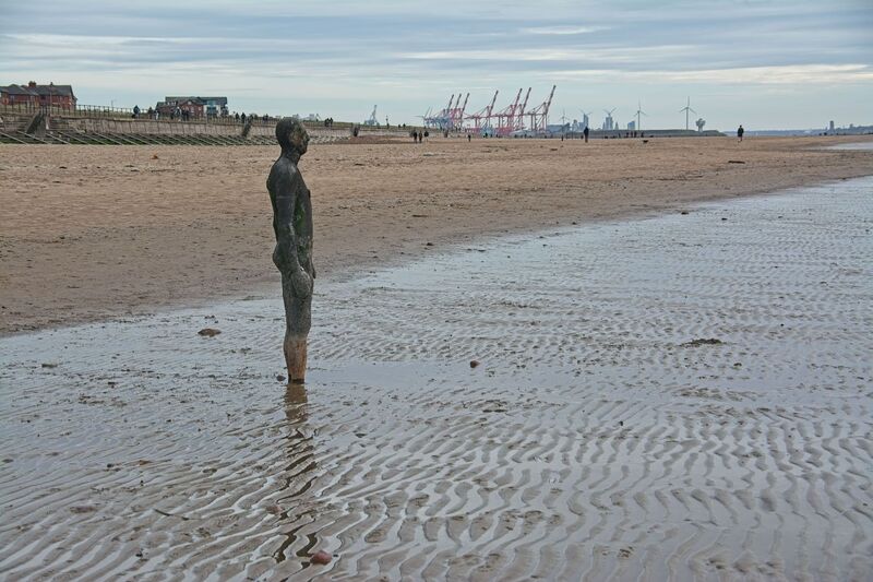 DC 24-0746-026.jpg :: Crosby Beech, Merseyside: Commonly referred to as ‘The Iron Men’ (or even the Crosby Beach statues), the art installation is officially called ‘Another Place’. Another Place was created by world-famous artist and sculptor Sir Antony Gormley, who famously created The Angel of the North. The Iron Men consist of 100 cast iron figures that have been installed along Crosby Beach facing the sea. The figures themselves are modelled from Antony Gormley’s body, and they were cast in the UK in both Halifax and West Bromwich. The Iron Men arrived in Liverpool in July 2005, but their story begins nearly 10 years earlier. In 1997, Another Place was first installed on Cuxhaven beach, in Lower Saxony, Germany. From there, they went to Stavanger in Norway and then to De Panne in Belgium. When The Iron Men found their new home at Crosby Beach in 2005, it was only supposed to be temporary. Photo taken 27/10/2024
