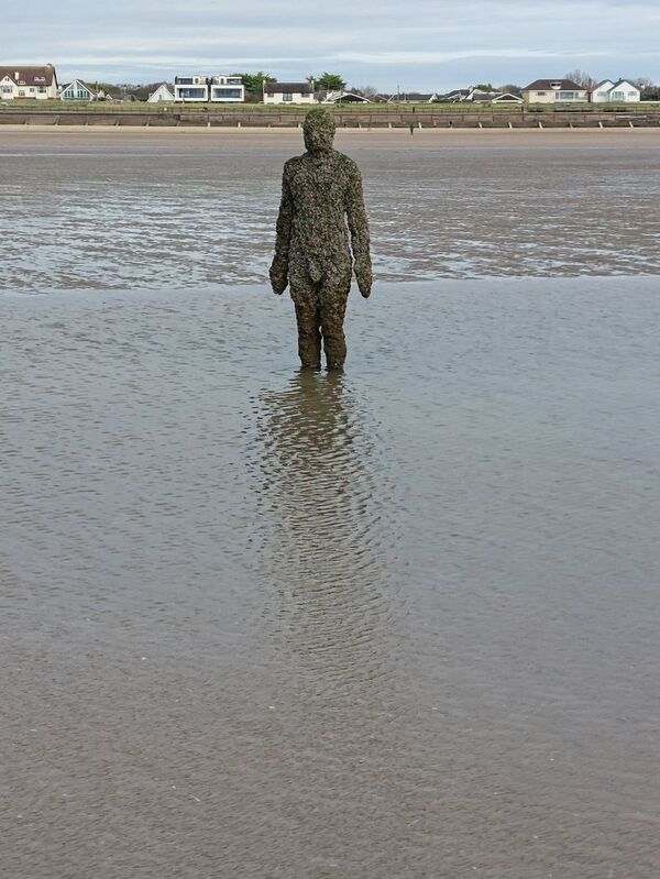 DC 24-0746-027.jpg :: Crosby Beech, Merseyside: Commonly referred to as ‘The Iron Men’ (or even the Crosby Beach statues), the art installation is officially called ‘Another Place’. Another Place was created by world-famous artist and sculptor Sir Antony Gormley, who famously created The Angel of the North. The Iron Men consist of 100 cast iron figures that have been installed along Crosby Beach facing the sea. The figures themselves are modelled from Antony Gormley’s body, and they were cast in the UK in both Halifax and West Bromwich. The Iron Men arrived in Liverpool in July 2005, but their story begins nearly 10 years earlier. In 1997, Another Place was first installed on Cuxhaven beach, in Lower Saxony, Germany. From there, they went to Stavanger in Norway and then to De Panne in Belgium. When The Iron Men found their new home at Crosby Beach in 2005, it was only supposed to be temporary. Photo taken 27/10/2024