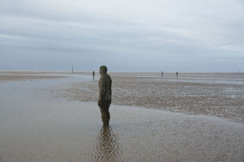 DC 24-0746-034.jpg :: Crosby Beech, Merseyside: Commonly referred to as ‘The Iron Men’ (or even the Crosby Beach statues), the art installation is officially called ‘Another Place’. Another Place was created by world-famous artist and sculptor Sir Antony Gormley, who famously created The Angel of the North. The Iron Men consist of 100 cast iron figures that have been installed along Crosby Beach facing the sea. The figures themselves are modelled from Antony Gormley’s body, and they were cast in the UK in both Halifax and West Bromwich. The Iron Men arrived in Liverpool in July 2005, but their story begins nearly 10 years earlier. In 1997, Another Place was first installed on Cuxhaven beach, in Lower Saxony, Germany. From there, they went to Stavanger in Norway and then to De Panne in Belgium. When The Iron Men found their new home at Crosby Beach in 2005, it was only supposed to be temporary. Photo taken 27/10/2024