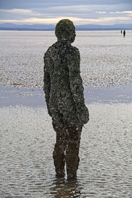 DC 24-0746-057.jpg :: Crosby Beech, Merseyside: Commonly referred to as ‘The Iron Men’ (or even the Crosby Beach statues), the art installation is officially called ‘Another Place’. Another Place was created by world-famous artist and sculptor Sir Antony Gormley, who famously created The Angel of the North. The Iron Men consist of 100 cast iron figures that have been installed along Crosby Beach facing the sea. The figures themselves are modelled from Antony Gormley’s body, and they were cast in the UK in both Halifax and West Bromwich. The Iron Men arrived in Liverpool in July 2005, but their story begins nearly 10 years earlier. In 1997, Another Place was first installed on Cuxhaven beach, in Lower Saxony, Germany. From there, they went to Stavanger in Norway and then to De Panne in Belgium. When The Iron Men found their new home at Crosby Beach in 2005, it was only supposed to be temporary. Photo taken 27/10/2024