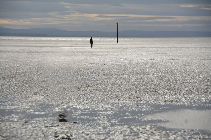 DC 24-0746-059a.jpg :: Crosby Beech, Merseyside: Commonly referred to as ‘The Iron Men’ (or even the Crosby Beach statues), the art installation is officially called ‘Another Place’. Another Place was created by world-famous artist and sculptor Sir Antony Gormley, who famously created The Angel of the North. The Iron Men consist of 100 cast iron figures that have been installed along Crosby Beach facing the sea. The figures themselves are modelled from Antony Gormley’s body, and they were cast in the UK in both Halifax and West Bromwich. The Iron Men arrived in Liverpool in July 2005, but their story begins nearly 10 years earlier. In 1997, Another Place was first installed on Cuxhaven beach, in Lower Saxony, Germany. From there, they went to Stavanger in Norway and then to De Panne in Belgium. When The Iron Men found their new home at Crosby Beach in 2005, it was only supposed to be temporary. Photo taken 27/10/2024