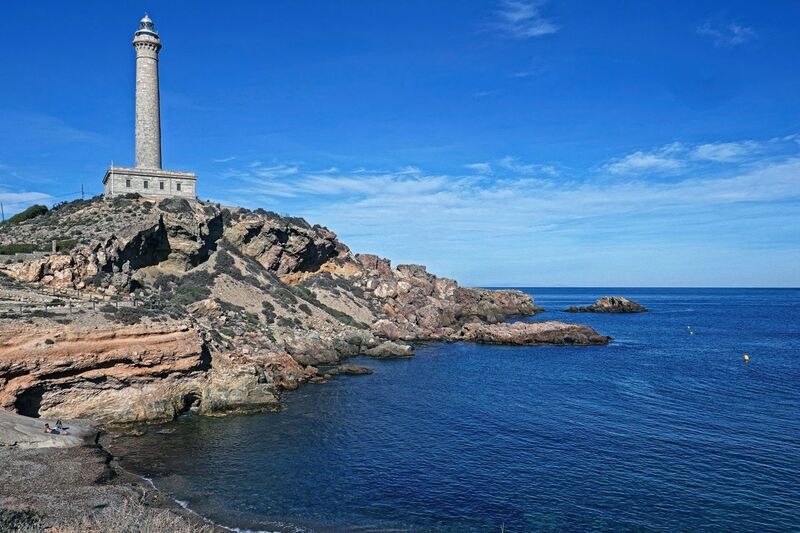 DC 24-0764-030.jpg :: Cabo de Palos, La Manga, Spain: The lighthouse of Cabo de Palos is located on an approximately 600 meters-wide small peninsula in the municipality of Cartagena. Back in its time, there was a watchtower where the lighthouse is currently located. The simple structure is defined by its surveillance function as well as the lighthouse-keepers school which was housed in its base. The construction started in 1863 and the lighthouse was first lit on the 31st January, 1865. The building rises 30 meters above sea level, according to Leonardo de Tejada's project. Ashlar stones brought in from a quarry located in the town of Sabinar were used as building material. It has a prism-shaped base of 20 meters on each side and 14 meters high with rusticated edges. In the middle of the base, above an octagonal shaped pedestal rises the 54 meters high tower. It adopts the form of a Tuscan order column, and its capital consists of various corbels that hold up a circular cornice with an openwork parapet in a shape of a balustrade. Above, there is a cylindrical tower where the lantern is built in. Nowadays, it has a beacon with a range of 24 miles. Photo taken 06/12/2024